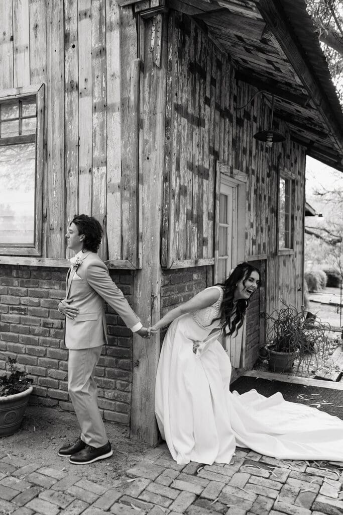 Bride doubles over in laughter as she shares a first touch with her groom with destination wedding photographer
