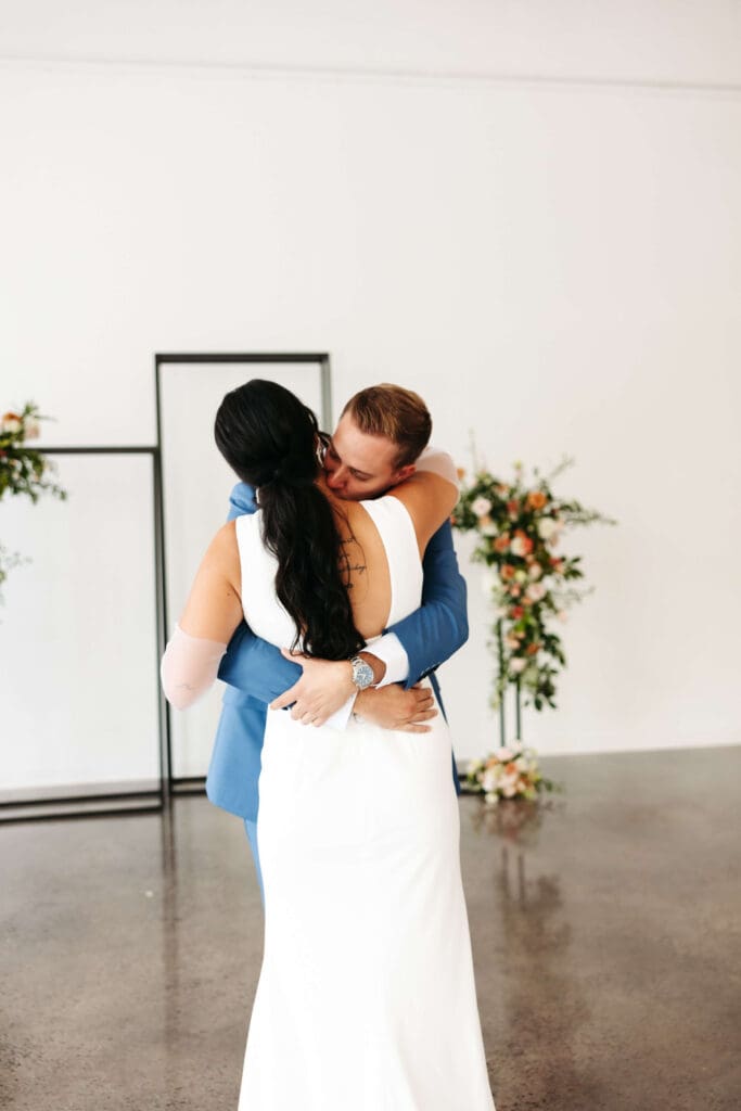 Groom kisses bride's neck during emotional first look