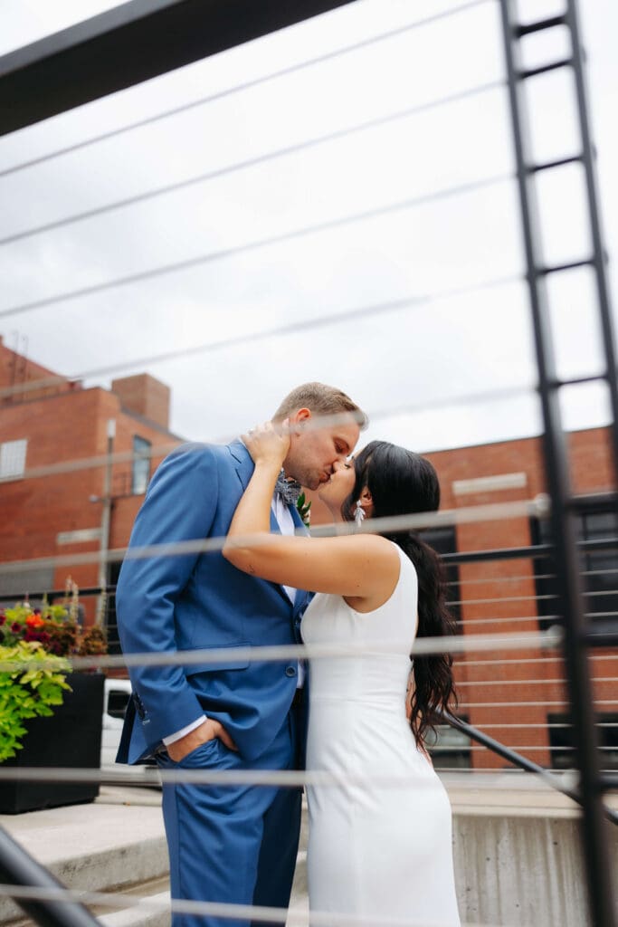 Bride and groom kiss outside industrial-chic wedding venue in downtown Minneapolis