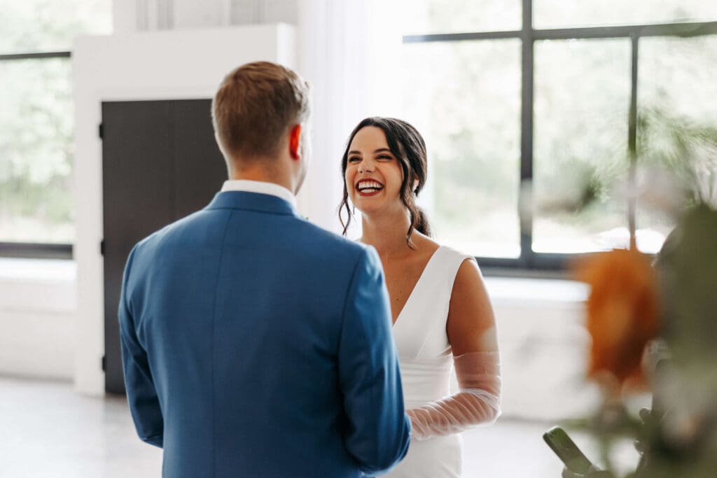 Bride smiles hugely as groom says his vows