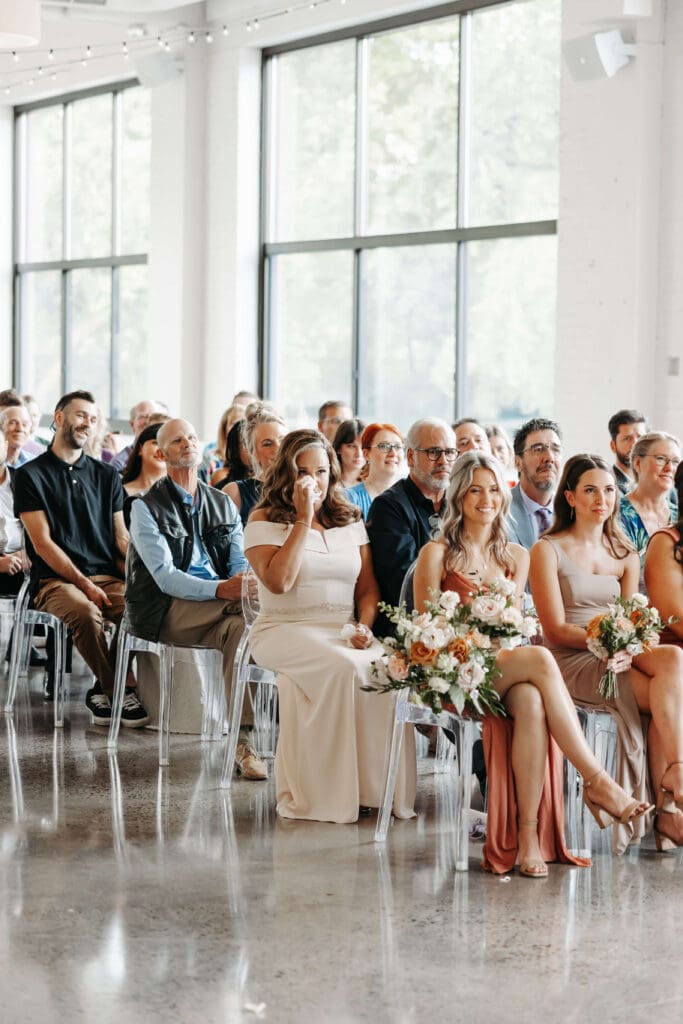 Mother of the bride wipes her eyes during wedding ceremony