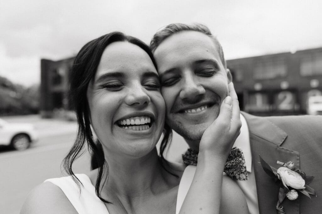 Bride and groom grin goofily in front of the camera