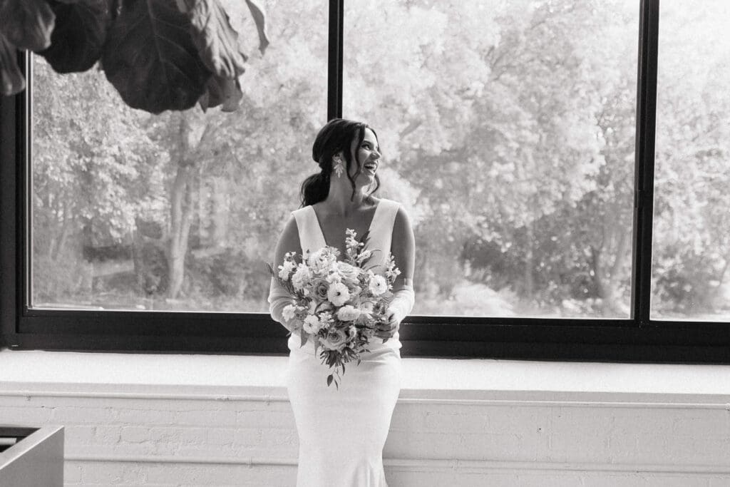 Bride holds bouquet and laughs 