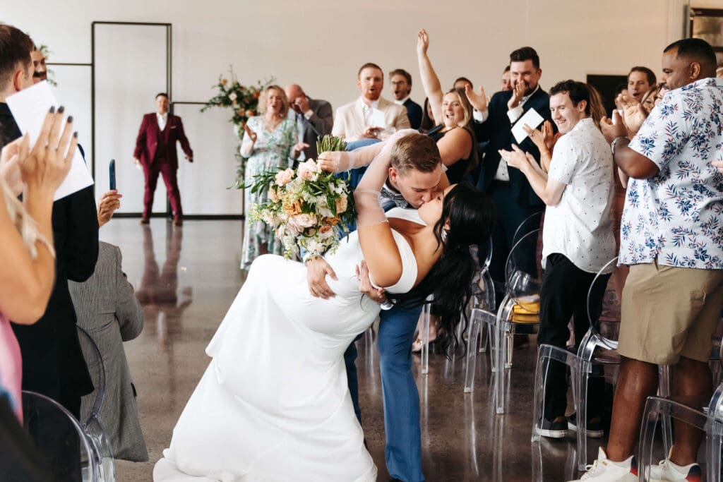 Groom dips bride in kiss at the end of the aisle