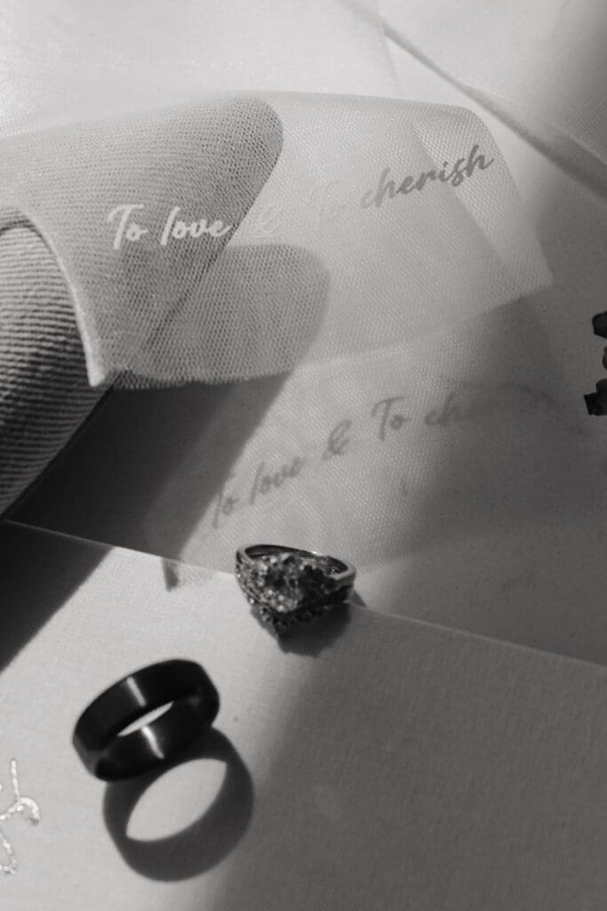 Bride's vow-embroidered gloves cast shadows over wedding rings
