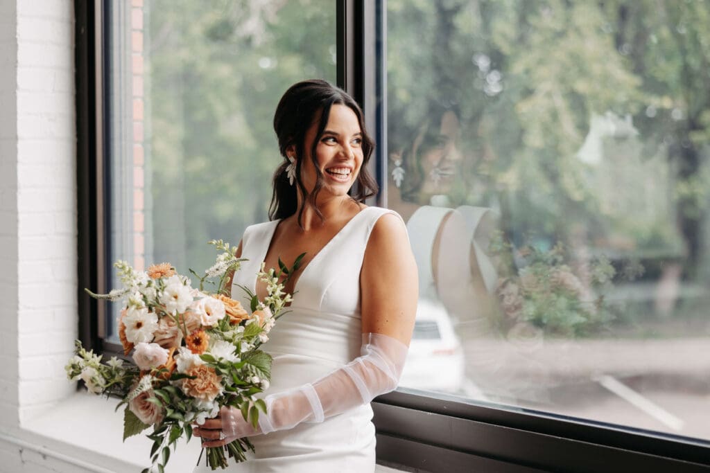Bride leans against windowsill