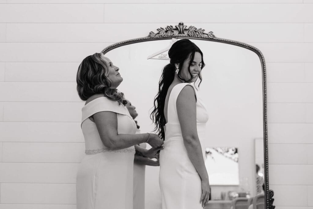 Bride's mother zips up her dress at Urban Daisy in downtown Minneapolis