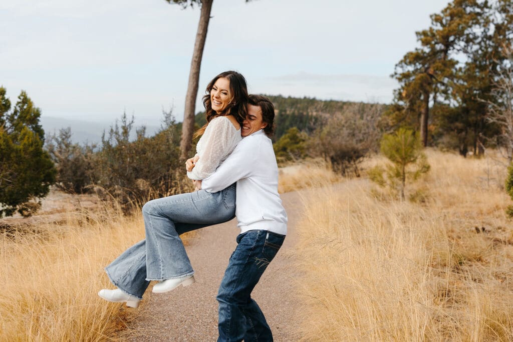 Kailey laughs as Easton twirls her on dusty Arizona trail.