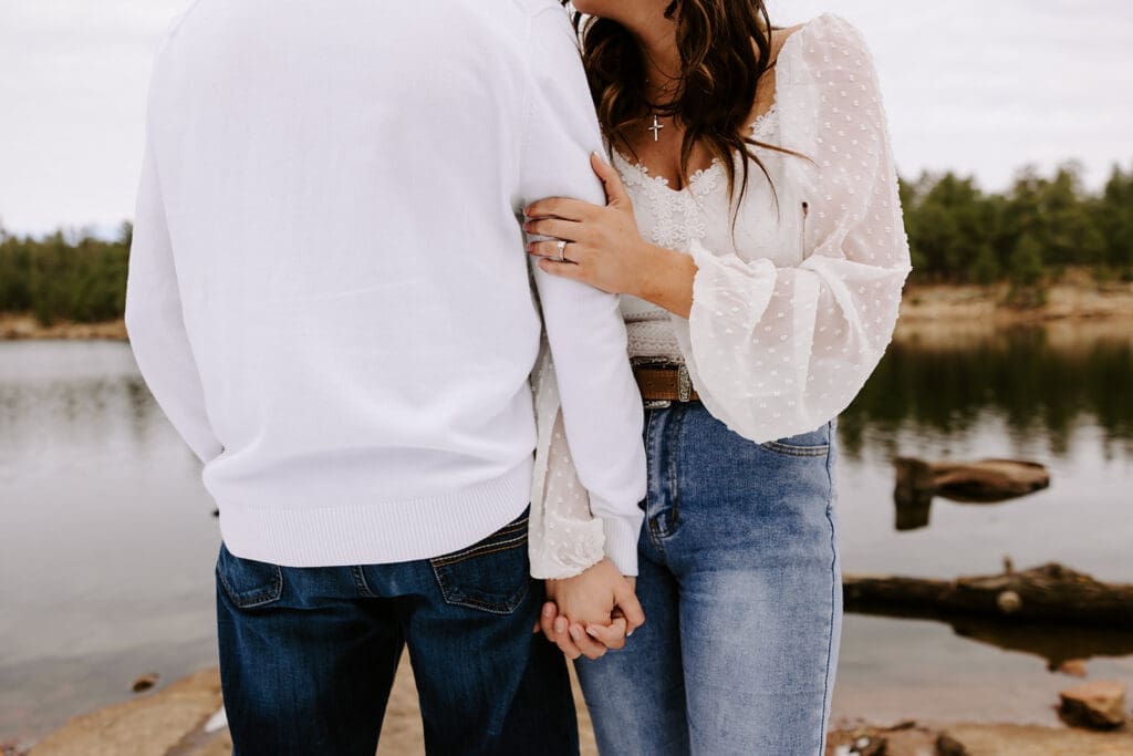 Snow-dusted lake engagement photo, Kailey wrapped in Easton’s arms.
