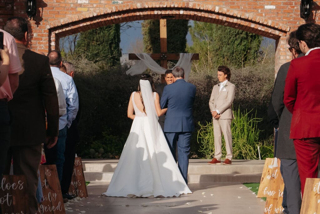 Destination wedding photographer captures bride making her way down the aisle towards her groom.