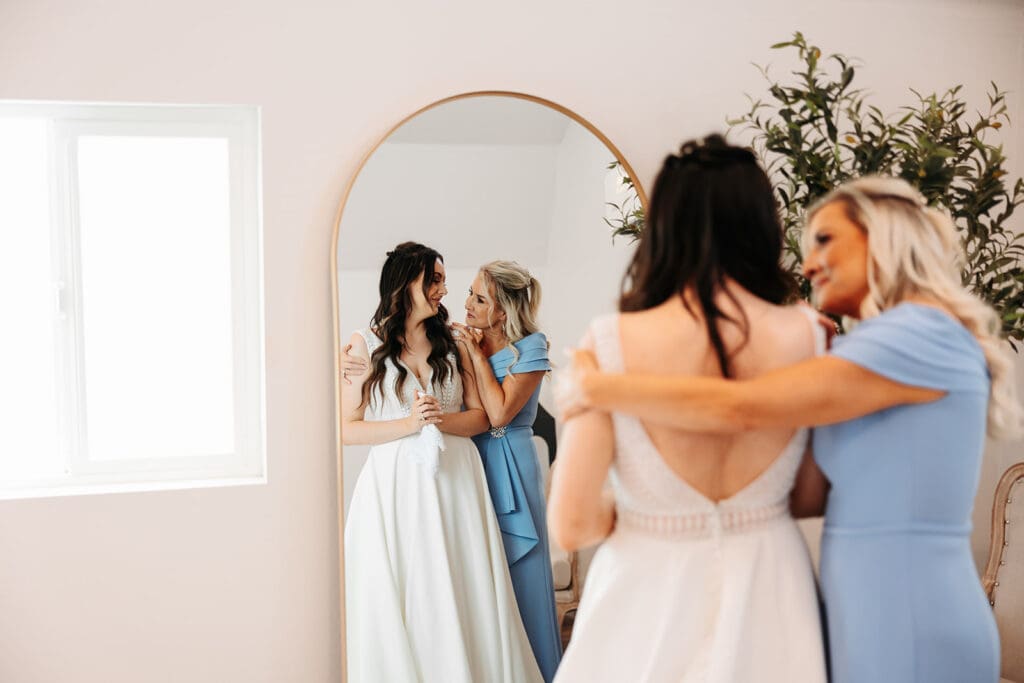 Kailey hugging her mom in the getting-ready suite—tears already flowing.