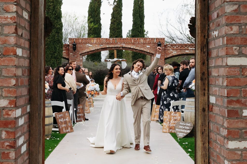 Just married! Kailey and Easton’s walk out of ceremony under open skies as guests cheer.