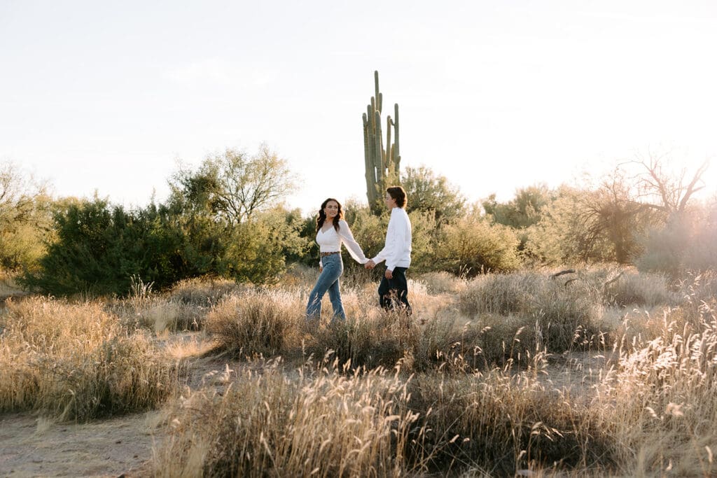 Kailey and Easton holding hands as golden hour hits the Arizona desert.