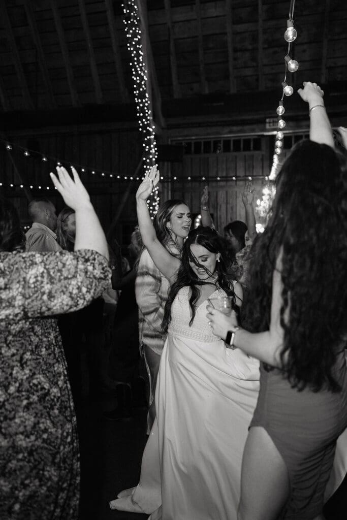 Bride dances under string-light adorned beams at Arizona wedding captured by destination wedding photographer