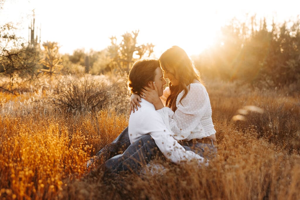 Couple sitting in a sun-drenched Arizona field.