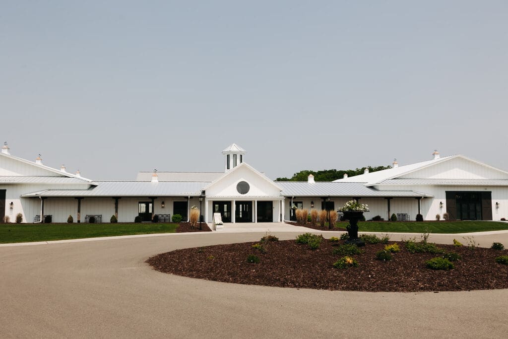 Exterior of Equestria West at Bavaria Downs, a modern white luxury wedding venue in Minnesota with clean architecture and landscaped grounds.