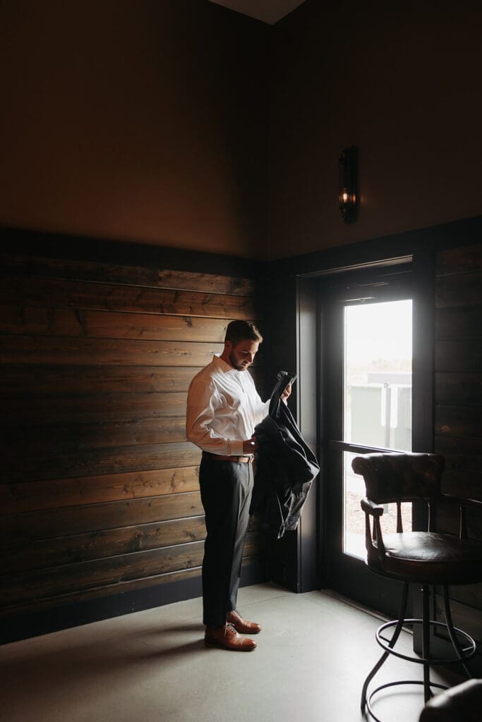 Groom getting ready in the warm wood groom's suite at Equestria West at Bavaria Downs.