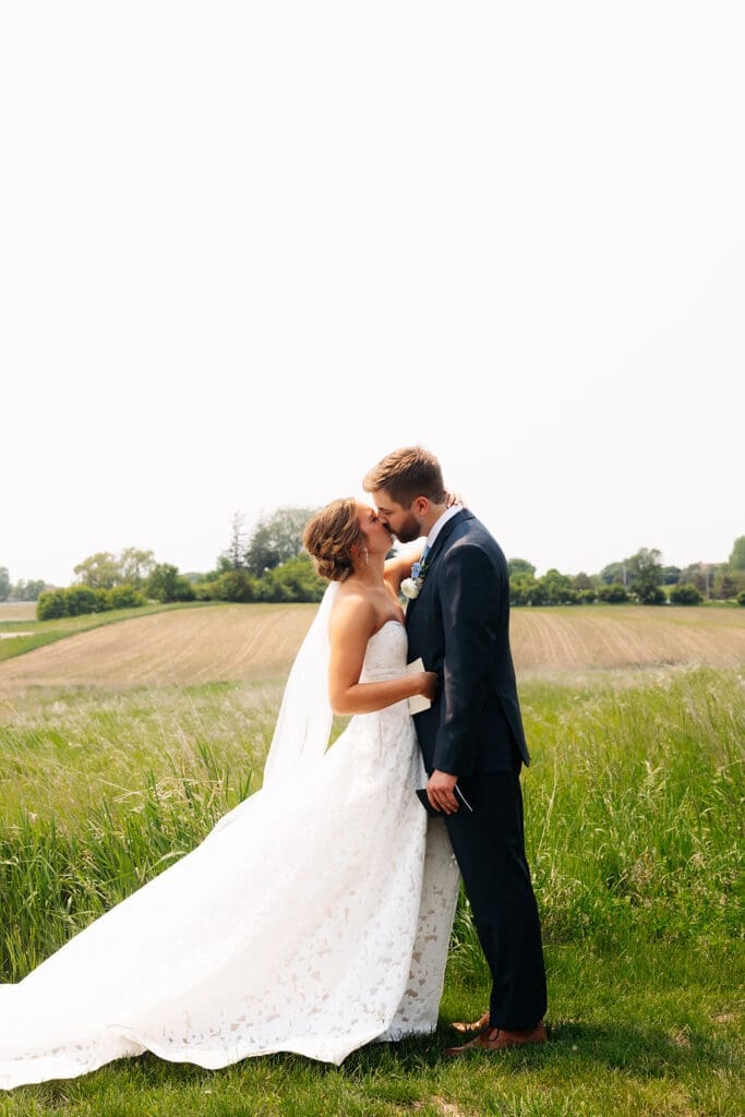 Bride and groom sharing portraits in the open fields surrounding this modern Minnesota wedding venue.