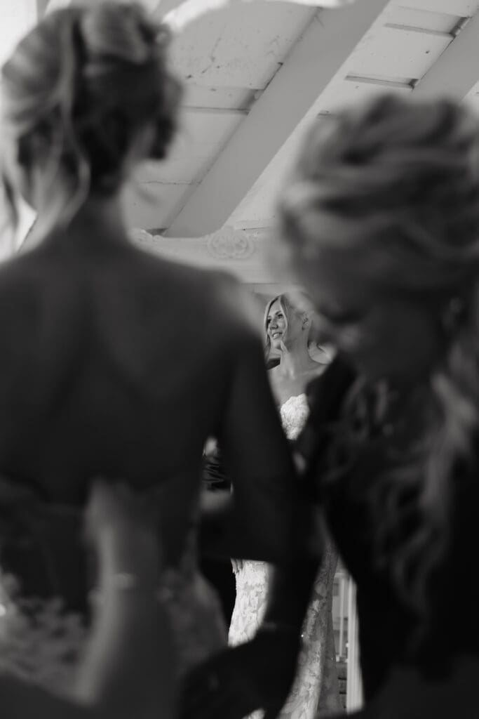 Bride seeing herself in the mirror while getting ready on her wedding morning at Redeemed Farm MN.