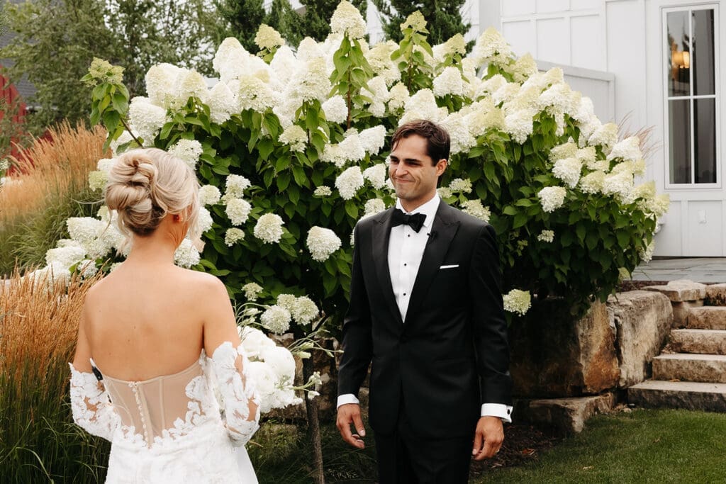 Groom smiles at his bride during their private wedding first look before the ceremony at Redeemed Farm.
