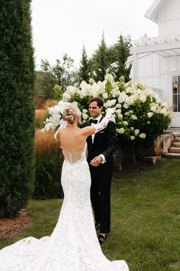 Bride approaches her groom during a garden first look, creating a private moment before the ceremony begins.