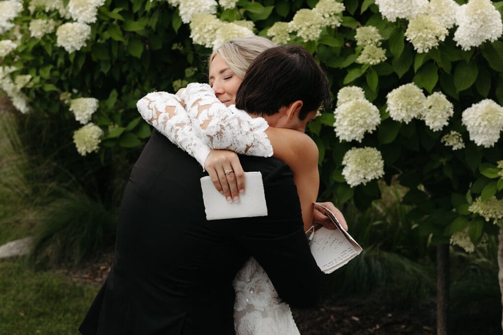 Bride and groom hug after exchanging private vows during their wedding first look before the ceremony.