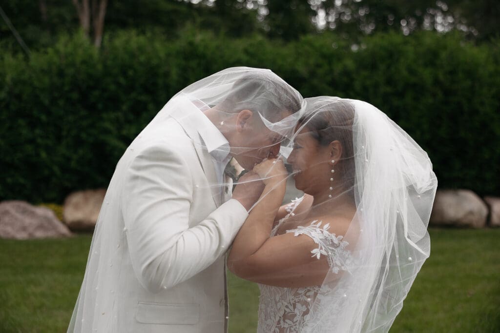 Bride and groom sharing a romantic veil portrait after their ceremony at this elegant riverfront wedding venue.