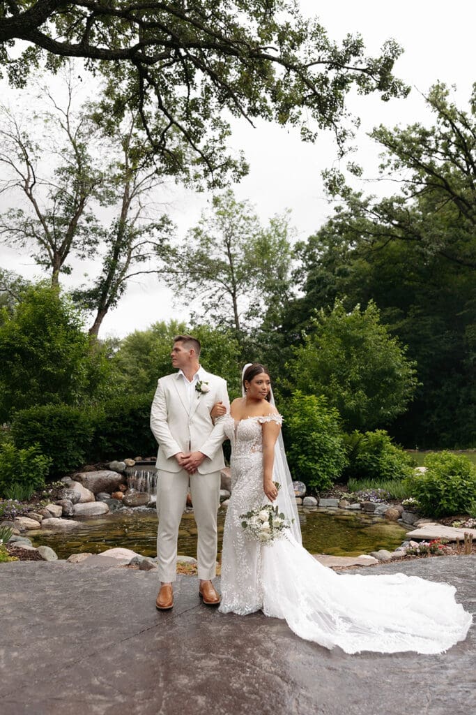 Bride and groom posing in the lush gardens surrounding this beautiful Minnesota wedding venue.