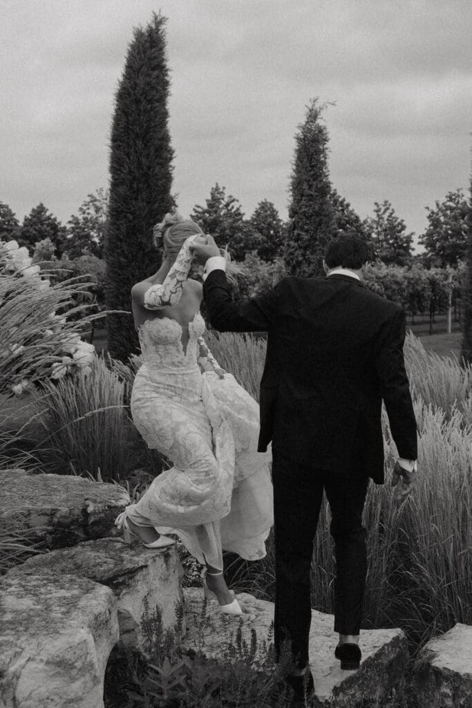 Bride and groom making their way through the hydrangea gardens after their ceremony at Redeemed Farm MN.
