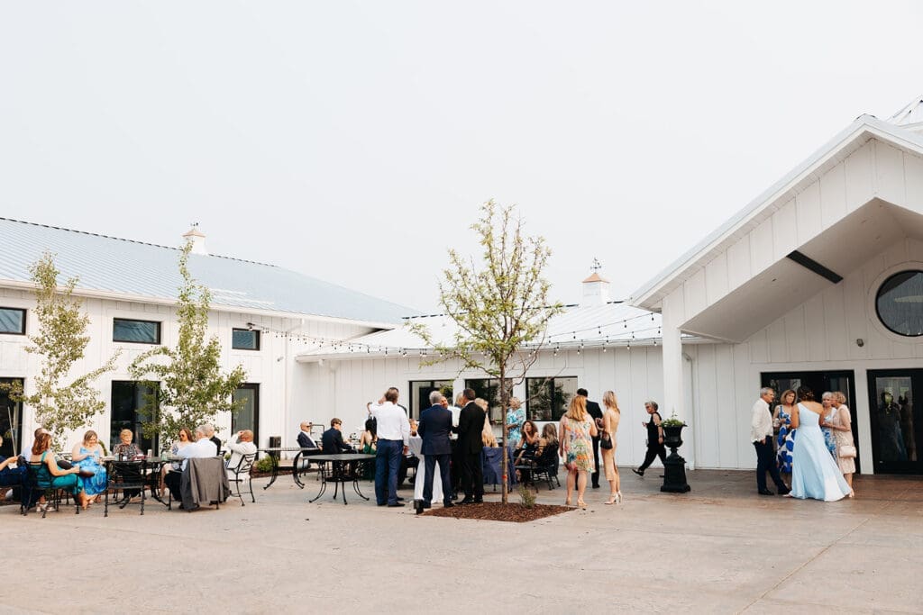 Guests enjoying cocktail hour on the spacious outdoor patio at Equestria West at Bavaria Downs.