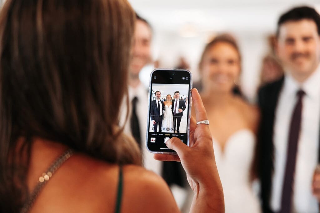 Wedding guest photographs the newlyweds during cocktail hour after first look photos freed up the timeline.