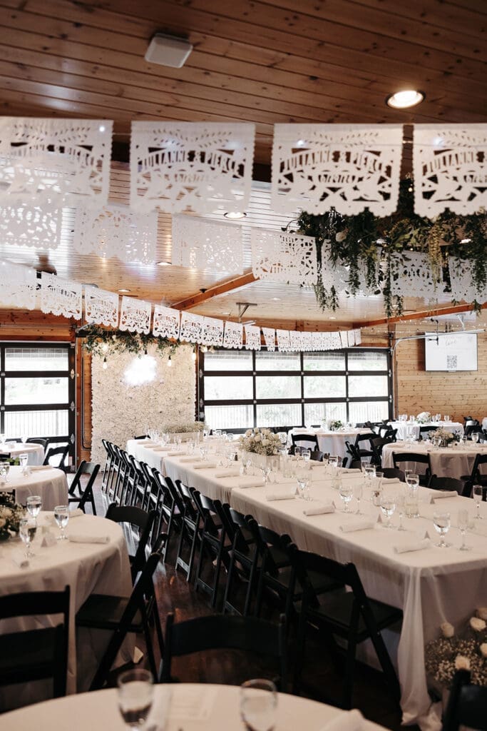 Reception tables beneath warm wood ceilings inside La Pointe Events in Osceola, Wisconsin, just outside the Twin Cities.