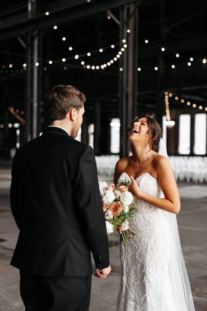 Bride laughs during emotional wedding first look with groom before the ceremony at Northern Pacific Center in Minnesota.