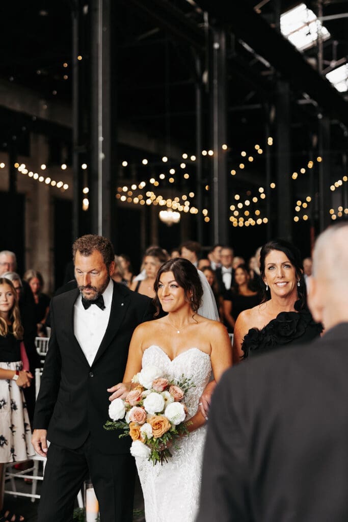 Bride walks down the aisle with her father after sharing a private wedding first look earlier in the day.