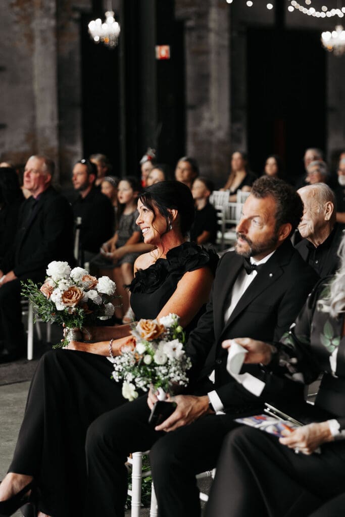 Parents of the bride watch the ceremony from the front row, an example of why intentional ceremony seating is one of the most overlooked wedding photo tips.