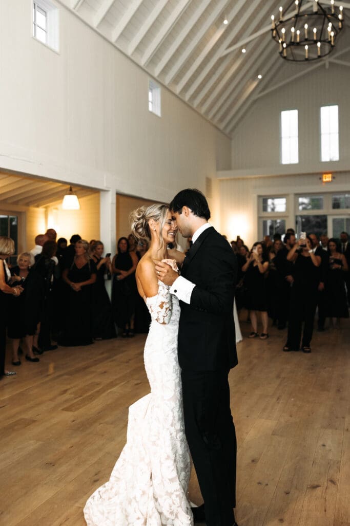 Bride and groom sharing their first dance beneath vaulted ceilings and chandeliers at Redeemed Farm MN.