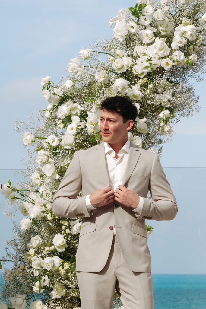 Groom gathers himself before seeing his bride during a beachfront wedding first look ceremony.