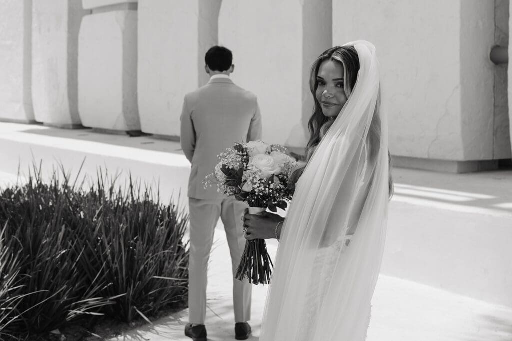 Bride smiles toward the camera as she approaches her groom for an emotional destination wedding first look before the ceremony at Grand Palladium Select Costa Mujeres.