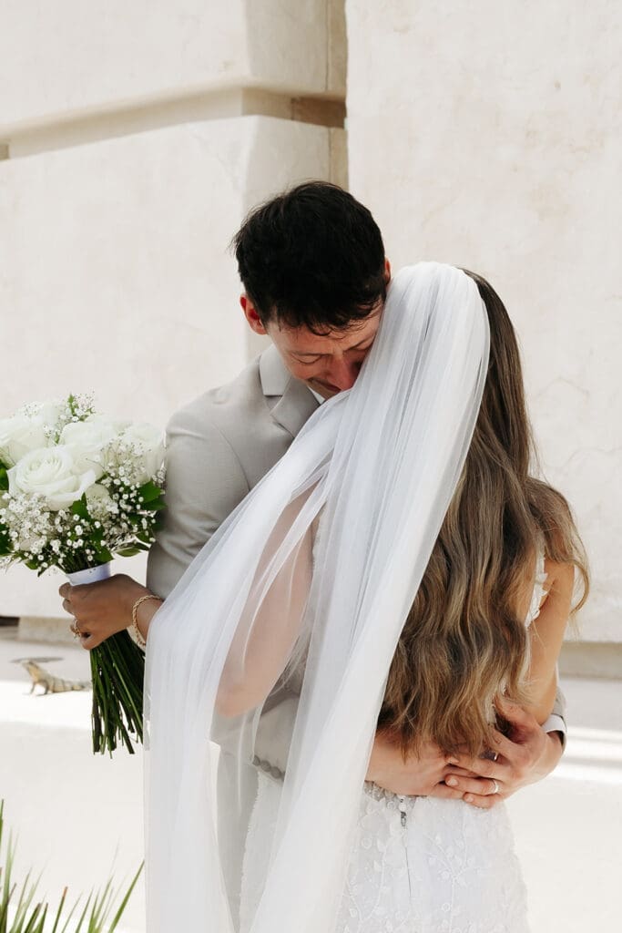 Groom hugs his bride after an emotional wedding first look at Grand Palladium Select Costa Mujeres , capturing the genuine connection that makes first look photos so meaningful.